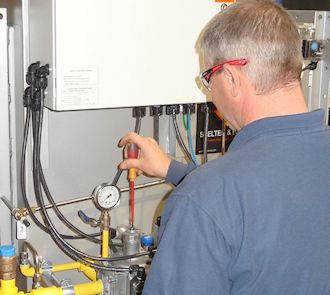 A man working on an industrial gas meter.