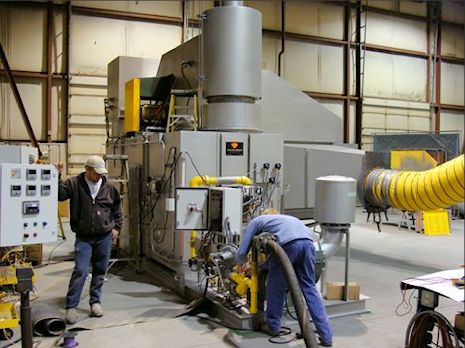 Two men working in a large machine shop.