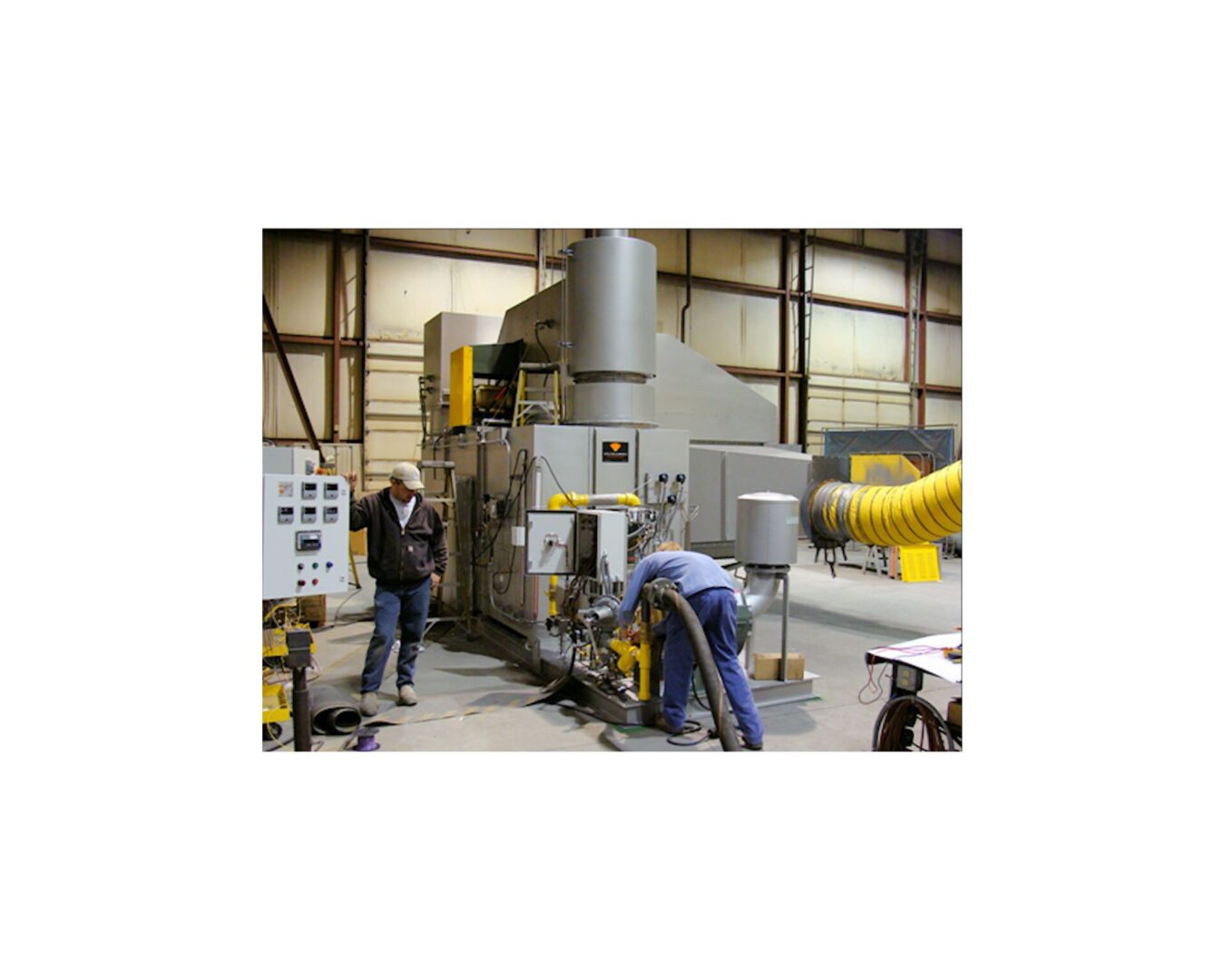 A man standing next to a machine in a factory.