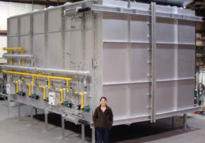 A man standing in front of an aluminum tank.