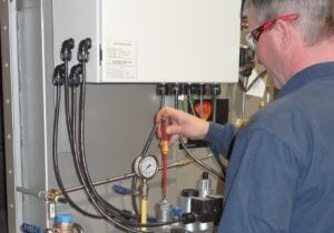 A man working on an industrial gas meter.