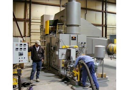 Two men working in a large machine shop.